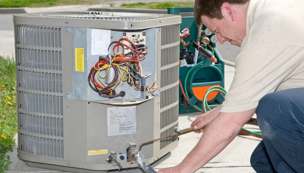 HVAC technician from Niebuhr in La Crosse, Wisconsin doing maintenance on an air conditioning unit.