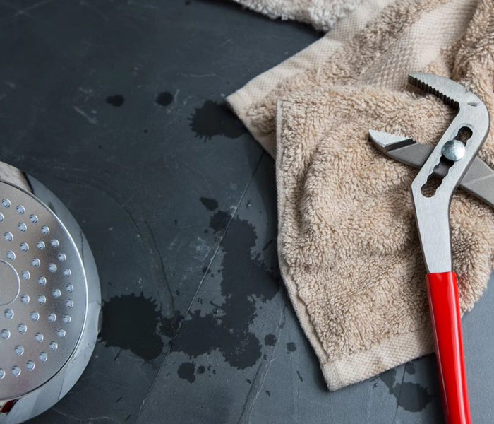 A channellock pliers laying on a hand towel ready to fix a showerhead.