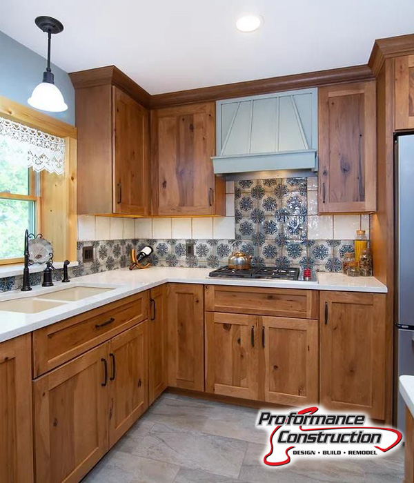 Proformance Construction kitchen remodel with Neibuhr plumbing & HVAC services, featuring a new sink, faucet, wood cabinets, and backsplash and countertop.