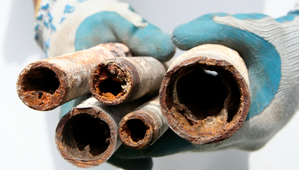 Corroded pipes severely damaged by hard water, illustrating the impact of scale buildup and corrosion on plumbing systems.