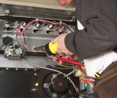 HVAC technician doing maintenance on a furnace.