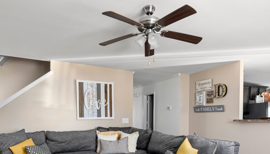 A homey living room space with a brown ceiling fan.