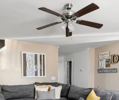 A homey living room space with a brown ceiling fan.