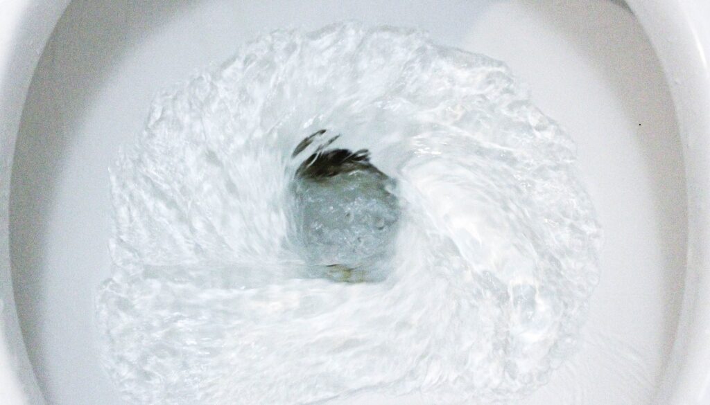 Close-up image of water swirling in a flushing toilet bowl