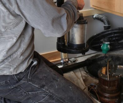 A professional plumber installs a sump pump in a residential basement