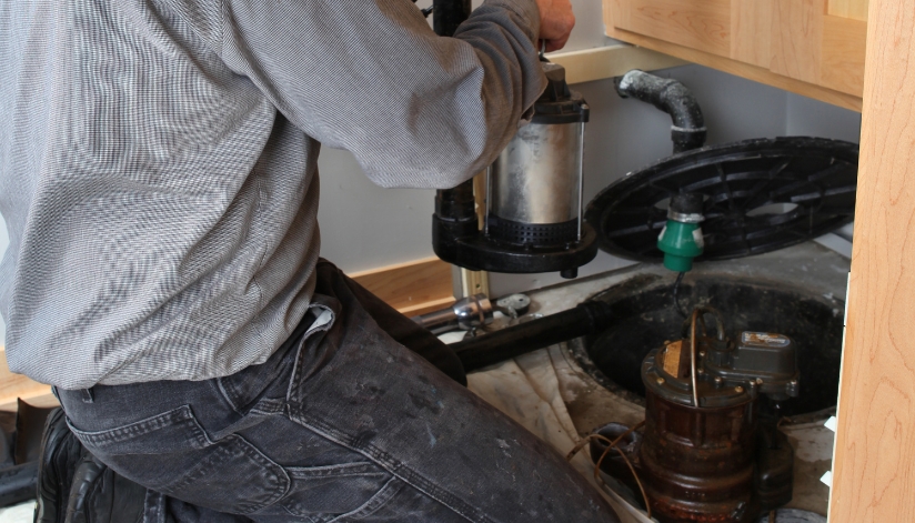 Sump Pump Vs. Sewage Ejector Pump: What’s The Difference? A professional plumber installs a sump pump in a residential basement