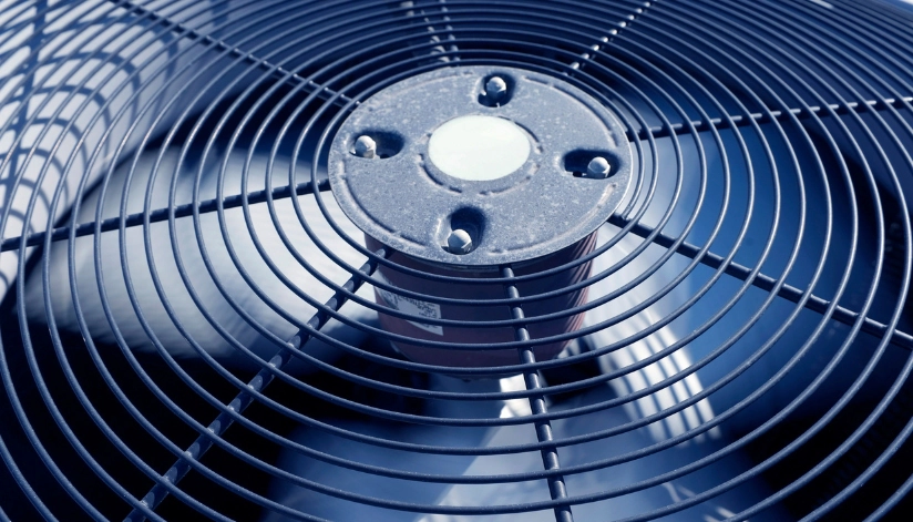 How Long Should An Air Conditioner Last? Close-up of an outdoor air conditioning unit fan.