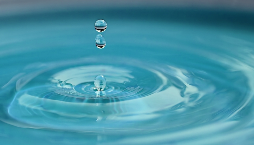 How A Water Softener Can Protect Your Plumbing And Improve Everyday Comfort Clean water droplets creating ripples, symbolizing the purity and softness of water after filtration by a home water softener.