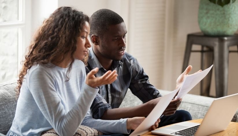 niebuhr-plumbing-heating-air-conditioning-oversized-furnace-symptoms-couple-looking-at-energy-bill-costs