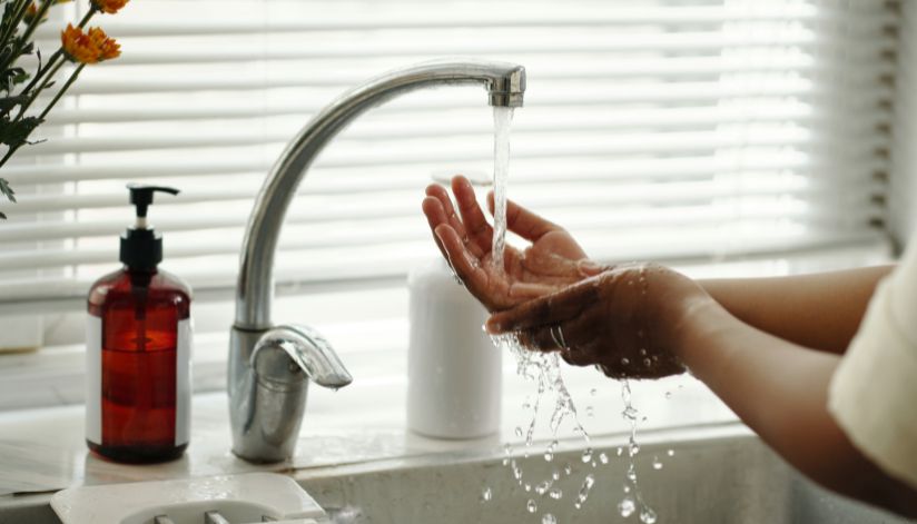 niebuhr-plumbing-heating-air-conditioning-what-slows-down-water-heater-and-delays-hot-water-hands-under-faucet