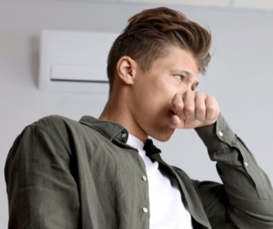 niebuhr-plumbing-heating-air-conditioning-why-AC-smell-when-you-turn-it-on-man-covering-nose