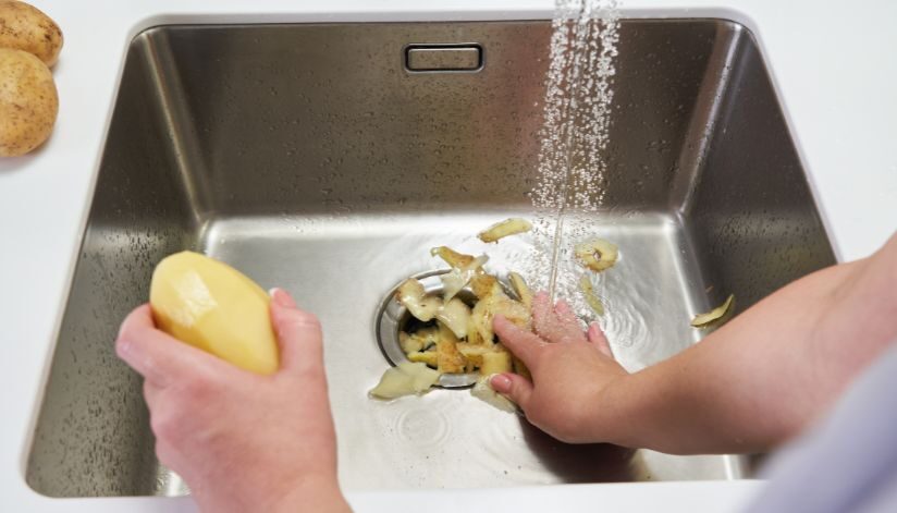 Homeowner disposes of potato peels after learning what should never go down a garbage disposal.