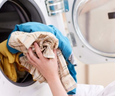 Woman taking clothes out of a dryer.
