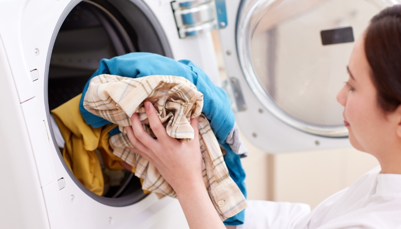 Woman taking clothes out of a dryer.