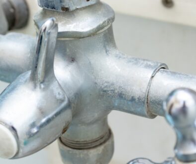 Silver faucet with hard water stains.
