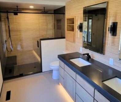 Modern bathroom remodel with a walk-in shower, double vanity, black fixtures, toilet, and updated plumbing fixtures in La Crosse, Wisconsin.